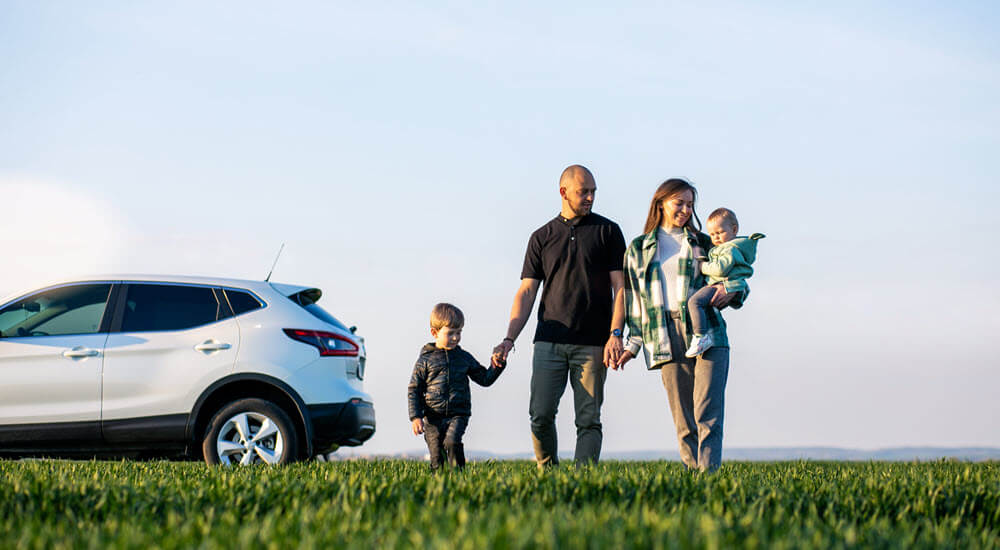 Young family with kids travelling by car, stopped in the field