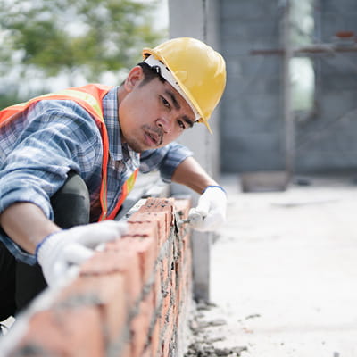 Male construction worker onsite wearing a hi-vis vest and hard hat