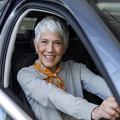 Woman smiling in the driver's seat of a car