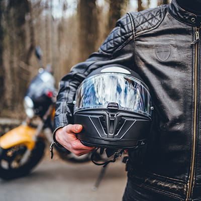 Close up of man carrying motorbike helmet under his arm