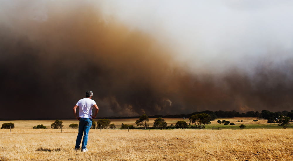 Man looking at bushfire in the distance